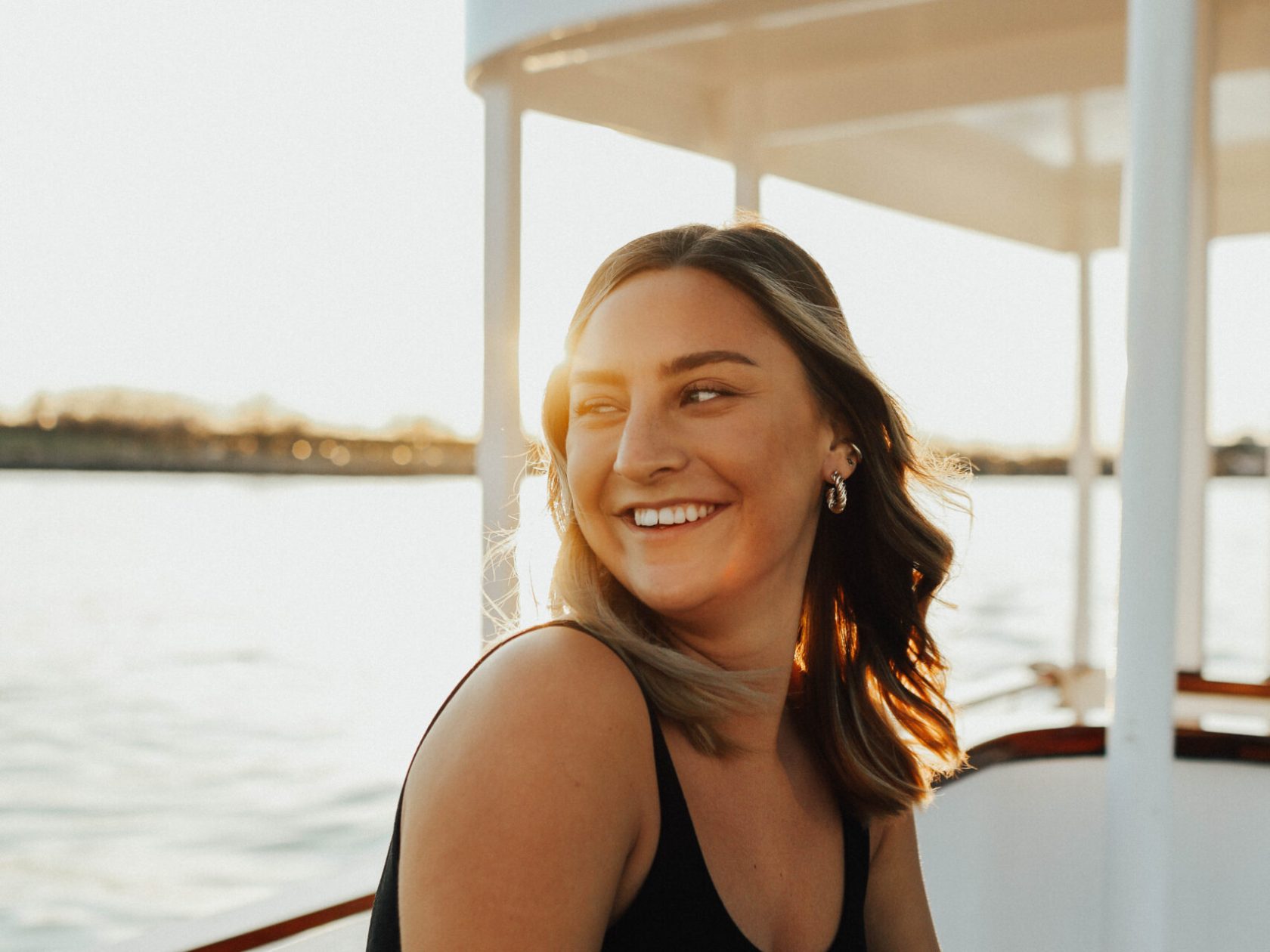 a woman standing in front of a body of water
