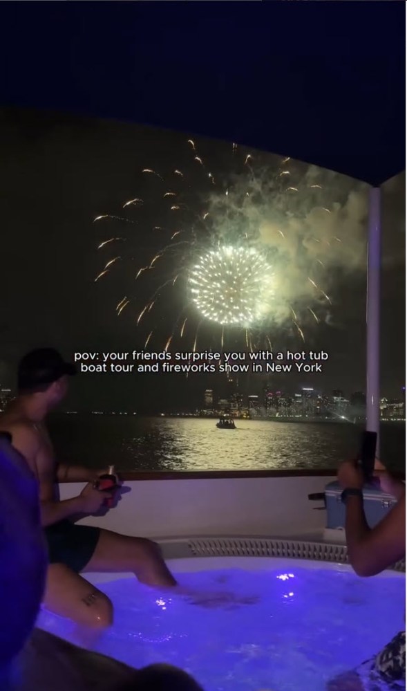 guys in DC Hot Tub Boat watching fireworks over city skyline at night.