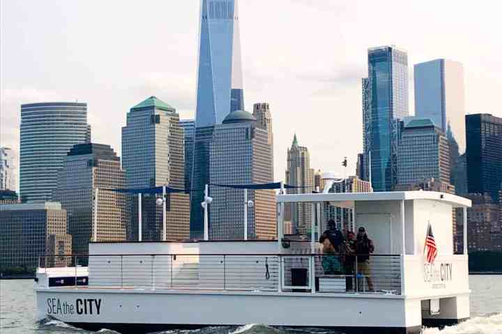 a large ship in a body of water with a city in the background