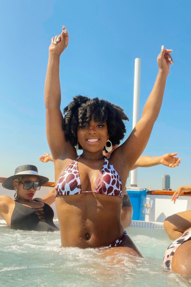 woman with arms in the air on hot tub boat in DC